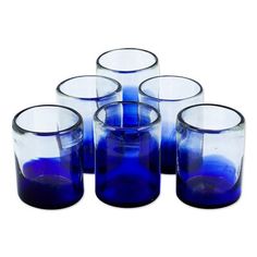 six blue glass vases sitting next to each other