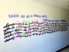 a wall that has some writing on it with words written in different colors and shapes