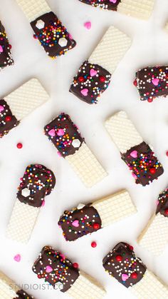 chocolate and sprinkles are arranged on top of ice cream bars with hearts