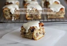 cinnamon swirl raisin biscuits with icing sitting on top of a white paper towel