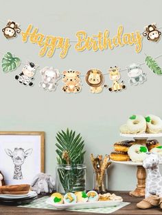 a happy birthday banner with animals hanging from it's side next to other decorations