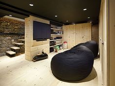 a living room filled with furniture and a flat screen tv on top of a wooden wall