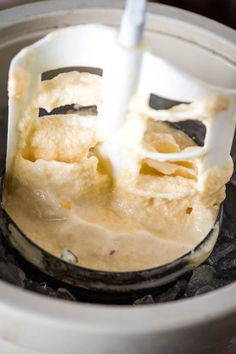 a blender filled with batter on top of an ice cream cone in a bowl