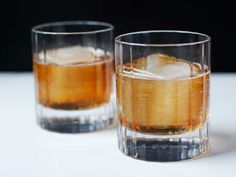 two glasses filled with ice sitting on top of a table