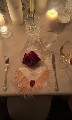 the table is set with silverware, candles, and napkins for an elegant dinner