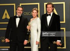 three people in tuxedos posing on the red carpet at an oscars event