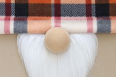 a close up of a piece of white hair and a plaid blanket on top of it