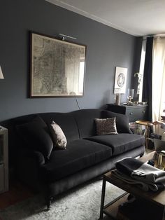 a living room filled with furniture and a large painting hanging on the wall above it