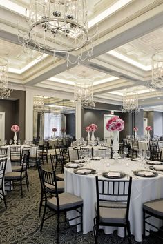 a banquet room with chandeliers, tables and chairs