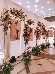 flowers and greenery are arranged on the wall in front of an event photo booth