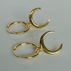 ▪︎ Gold plated sterling silver ear hoops. Comes with a sterling silver gold plated crescent moon charm. ▪︎ Dimensions-- Hoops: 1.2 x 12 mm Crescent moon :10.5 x 12.5 mm. ▪︎ These hoops are handmade with hypoallergenic 925 sterling silver plated in gold. ▪︎ Please note: You can wear these hoops with or without the charm. ▪︎ This multipurpose charm can be worn with necklaces, earrings, bracelets etc. ▪︎ I can send this piece in a gift box or include a gift message from you if required. ▪︎▪︎ Please Adjustable Moon-shaped Minimalist Earrings, Minimalist Adjustable Crescent Earrings, Earrings Gold Hoops, Wanderlust Jewelry, Casual Earrings, Hoops Gold, Gold Gift, Silver Moon, Moon Charm