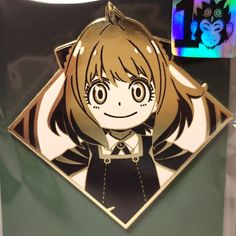 a close up of a magnet with a cat on it's head and an anime character in the background