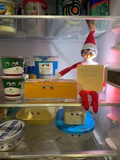 an elf is holding a piece of cake in the refrigerator