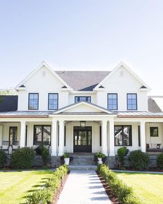 a large white house sitting on top of a lush green field