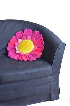 a stuffed flower sitting on top of a blue chair