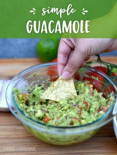 someone dipping guacamole into a glass bowl