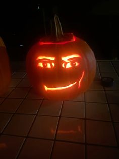 two pumpkins with faces carved into them