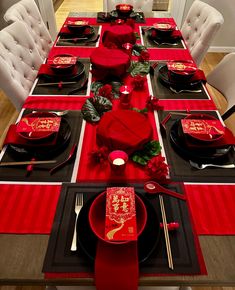 the table is set with red and black plates, silverware, and napkins