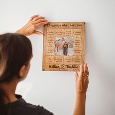 a woman holding up a framed photo with the words, i love you and an image of two people