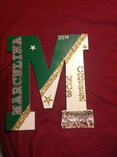 the letter m is decorated with gold and green glitters on a red shirt that says merry christmas