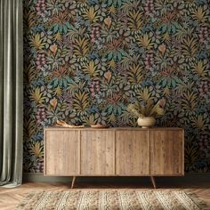 a wooden cabinet sitting in front of a wallpapered wall with flowers on it