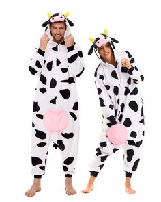 man and woman in cow onesuits standing next to each other with thumbs up