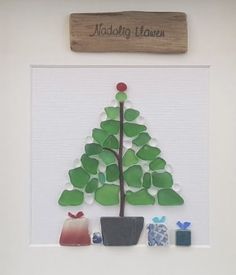 a christmas tree made out of paper and some other items in front of a sign that reads naddalg haven