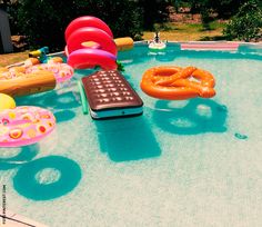 an inflatable pool with toys and other items around it, including a remote control