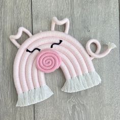 a pink cat with a white mane on it's head and eyes are made out of yarn