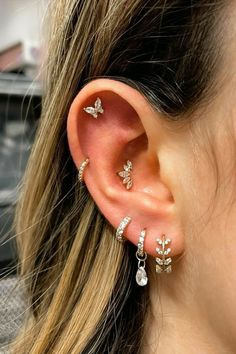 a close up of a person with ear piercings on their ears and behind the ear