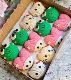 a box filled with lots of decorated cookies in different colors and designs on top of a table