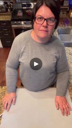 a woman sitting in front of a cutting board