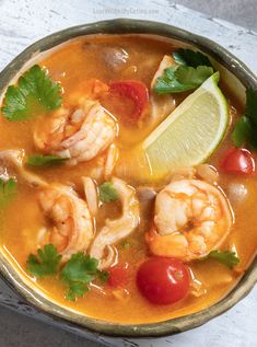 a bowl filled with shrimp, tomatoes and cilantro