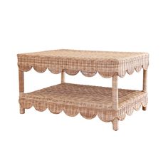 a wicker coffee table with scalloped edges and a shelf on the top