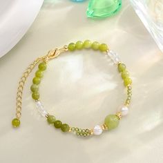 Indulge in the refreshing nature of summer with our Green Grape Beaded Bracelet. The vibrant green grapes, paired with shimmering pearls and cubic zirconia, create a playful and graceful accessory that will light up people's eyes. Embrace the fabulous and exquisite feel of this bracelet and add a touch of coolness to your wardrobe.  DETAILS Plating: 18K Gold Materials:   18K Gold on Brass,   Pearl, Cubic Zirconia, Gemstones Measurements: Length: 5.91 "(15cm)   + Extender: 1.97"(5cm) Weight: 5.8 Elegant Pearl Bracelet With Round Beads For Summer, Elegant Summer Pearl Bracelet With Round Beads, Elegant Beaded Pearl Bracelet For Summer, Elegant Summer Beaded Bracelets With Round Beads, Elegant Green Beaded Bracelets With Natural Stones, Elegant Colorful Beaded Bracelets For Summer, Green Beaded Bracelets For Summer Gifts, Elegant Green Crystal Bracelet With Natural Stones, Elegant Summer Pearl Bracelet