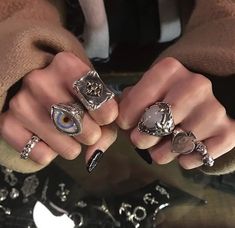 two women with rings on their fingers and one has an eyeball in the middle