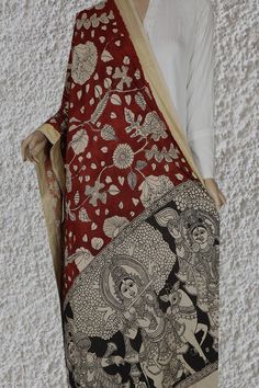 a woman wearing a red and black sari with an elephant design on it's back