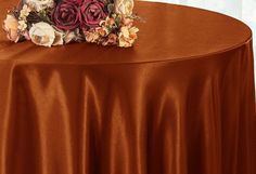 a table with a brown cloth and flowers on it