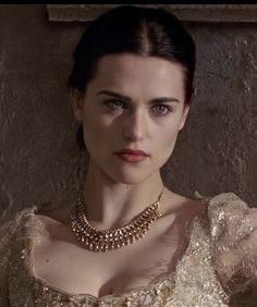 a woman wearing a gold necklace and dress in a scene from the tv game of thrones