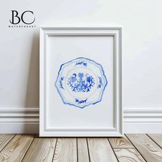 a blue and white plate sitting on top of a wooden floor next to a wall