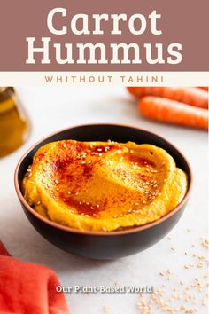 carrot hummus in a black bowl on a white table