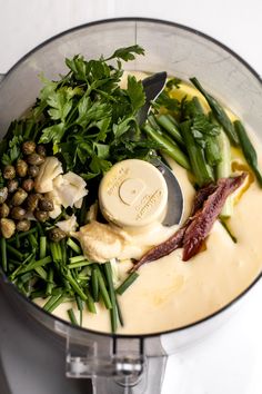 a food processor filled with green vegetables and other things to make it look like an appetizer