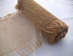 a close up of a piece of cloth on a white tablecloth with fringes