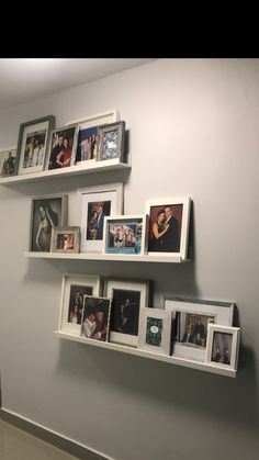 some white shelves with pictures and frames on them