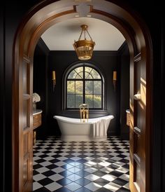 an open door leading to a black and white checkered bathroom with a claw foot tub