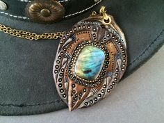 "\"For Becky\" is a hand tooled leather fantasy pendant in bronze palette with spectacular rainbow labradorite cabochon in the middle. This one of a kind piece would drag attention to the place where it hangs ;) Listing includes a bronze or copper chain, thus please provide me with the desired length and choice upon purchase. Your parcel will be sent by priority airmail service. This particular pendant was MADE TO ORDER but it's just one of many more I can make. If you would like me to customize Handmade Bronze Fantasy Jewelry, Bronze Cabochon Bohemian Jewelry, Bronze Bohemian Jewelry With Cabochon, Bohemian Bronze Cabochon Jewelry, Bronze Bohemian Cabochon Jewelry, Artisan Bronze Labradorite Necklace, Artisan Labradorite Bronze Necklace, Bronze Bohemian Necklace With Cabochon, Bohemian Labradorite Collectible Jewelry