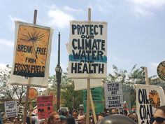 people holding protest signs and helmets in the street