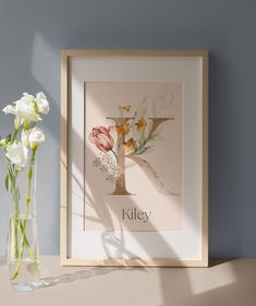 a vase filled with white flowers next to a framed photo