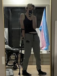 a woman standing in front of a mirror taking a selfie