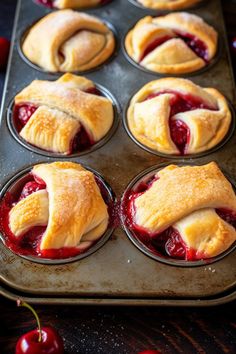 freshly baked cherry pies in muffin tins with cherries on the side